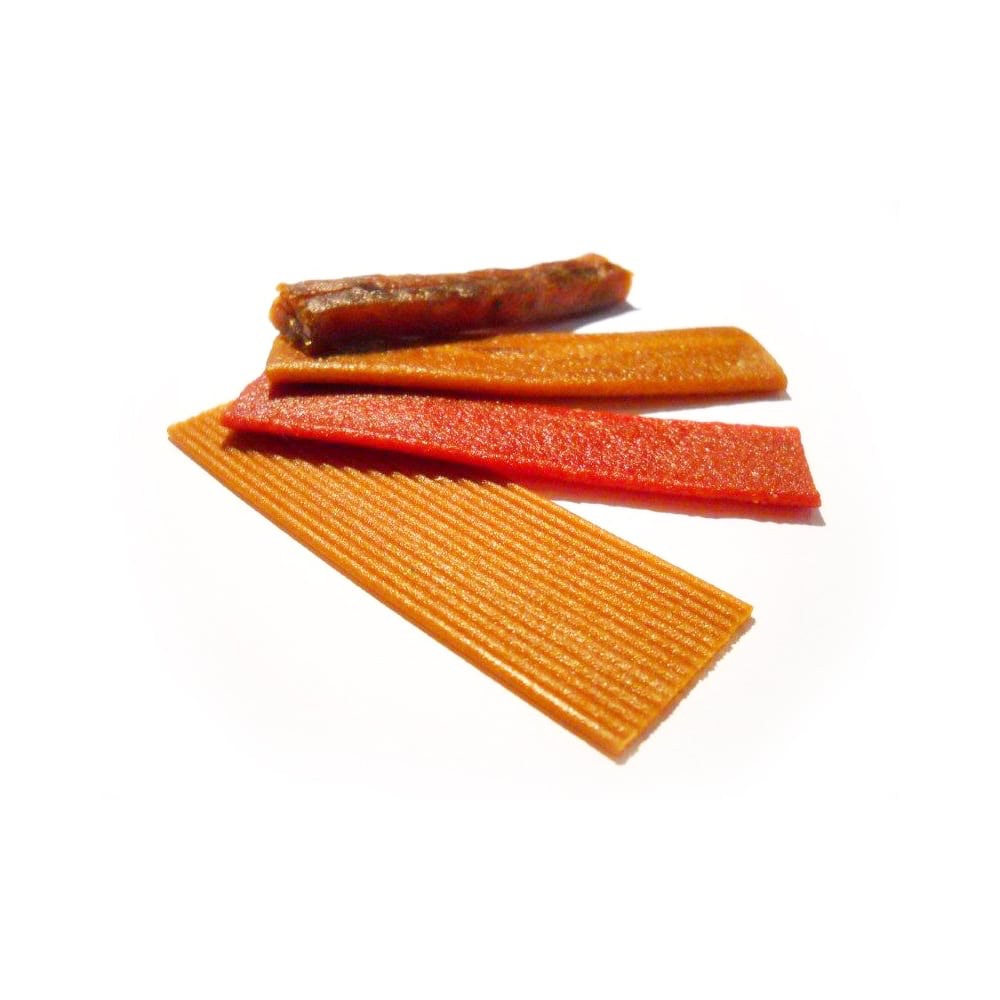 Extruded fruit snack belts in red and orange — made from processed fruit and fruit purees